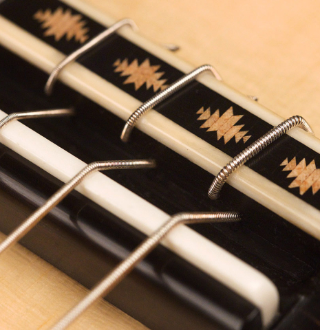 The bridge and saddle of a 2021 Erez Perelman classical guitar made of spruce and cypress