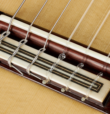 The bridge, tie-block and saddle of a 2024 Teodoro Perez "Antigua" classical guitar made of spruce and African rosewood