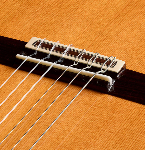 The bridge, tie-block and saddle of a 2026 Teodoro Perez "Estudio C-650" classical guitar made of cedar and Indian rosewood