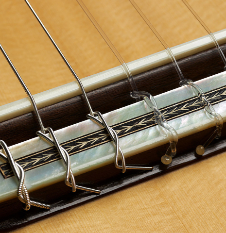 The bridge, tie-block and saddle of a 2024 Teodoro Perez "Especial" classical guitar made of spruce and African ebony