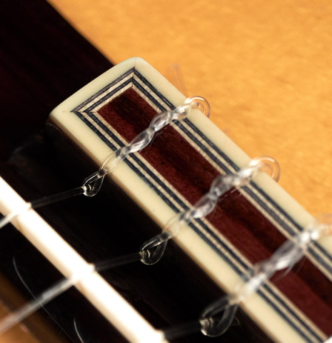 The bridge and tie block of a 2023 Teodoro Perez "Estudio C-650" classical guitar made of spruce and Indian rosewood.