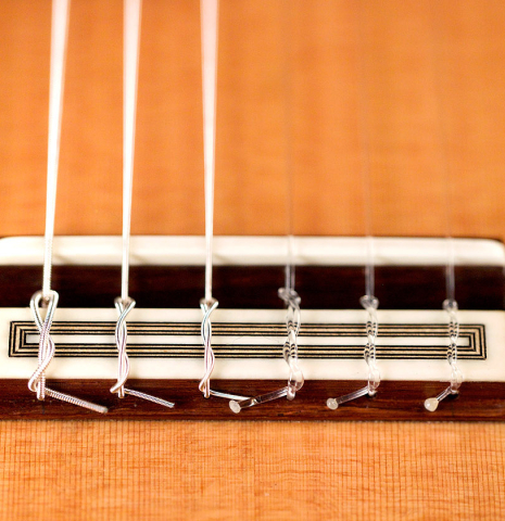 The bridge, tie block and saddle of a 2021 Teodoro Perez "Antigua" classical guitar made with cedar top and African rosewood back and sides.