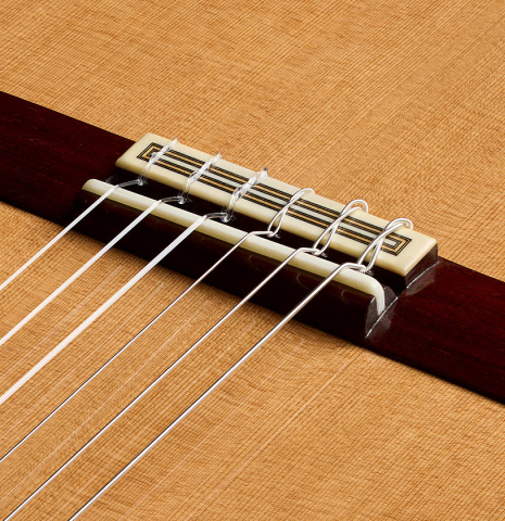 The bridge, tie-block and saddle of a 2026 Teodoro Perez "Antigua" classical guitar made of cedar and African rosewood