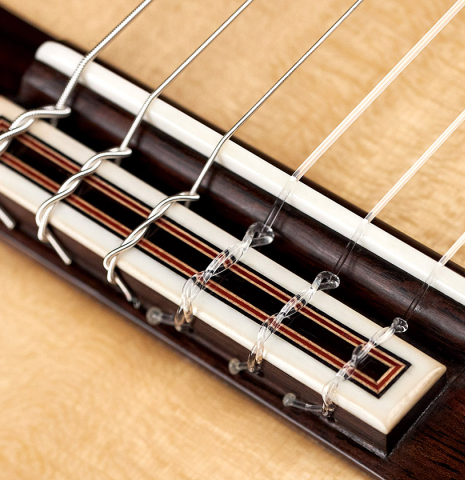 The bridge and saddle of a 2023 Sergio Perez "Segovia" model of classical guitar made of spruce and green ebony. 