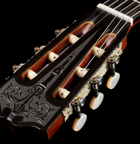 The carved head and tuning machines of a 2007 Daryl Perry "Simplicio" classical guitar made with spruce and satinwood