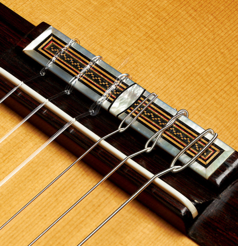 The bridge, tie-block and saddle of a 2007 Daryl Perry "Simplicio" classical guitar made with spruce and satinwood