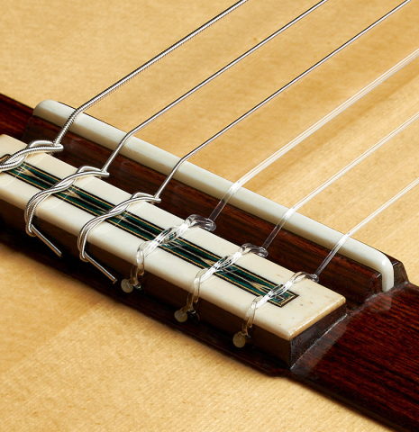 The bridge, tie-block and saddle of a 2024 Teodoro Perez "Especial" classical guitar made of spruce and Bubinga