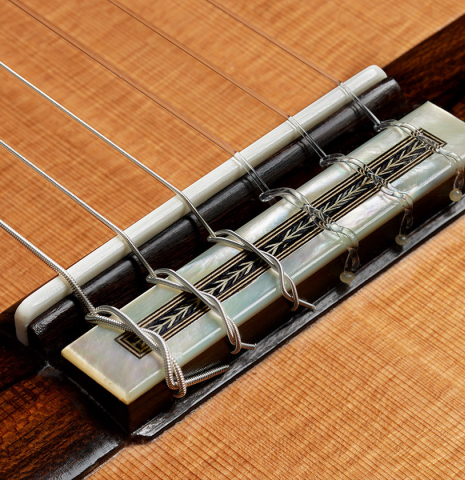 The bridge, tie-block and saddle of a 2024 Teodoro Perez "Especial" classical guitar made of cedar and African ebony