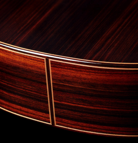 The sides at the foot of a 2024 Sergio Perez "Segovia" classical guitar made of spruce and Indian rosewood.