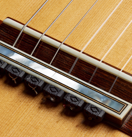 The bridge, tie-block and saddle of a 2000 Daryl Perry classical guitar made of spruce and CSA rosewood
