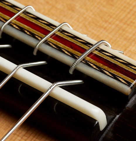 The bridge, tie-block and saddle of a 2025 Erez Perelman classical guitar made of cedar and CSA rosewood