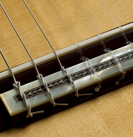 The bridge, tie-block and saddle of a 2025 Teodoro Perez "Especial" classical guitar made of spruce and Makassar ebony