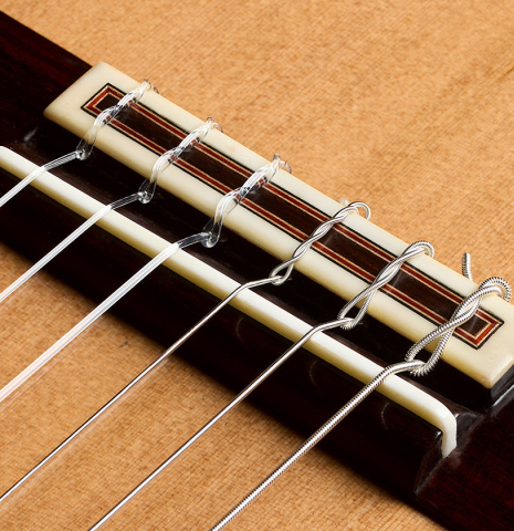 The bridge, tie-block and saddle of a 2026 Sergio Perez "Segovia" classical guitar made of cedar and Indian rosewood