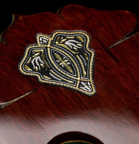 The medallion logo inlaid into the headstock veneer of a 2026 Teodoro Perez "60th Anniversary" classical guitar made of cedar and African rosewood