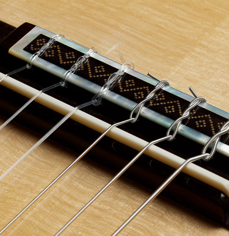 The bridge, tie-block and saddle of a 2024 Jose Marin Plazuelo "Bouchet" classical guitar made of spruce and CSA rosewood