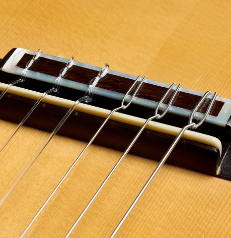 The bridge, tie-block and saddle of a 1999 Jose Marin Plazuelo "Bouchet" classical guitar made of spruce and CSA rosewood