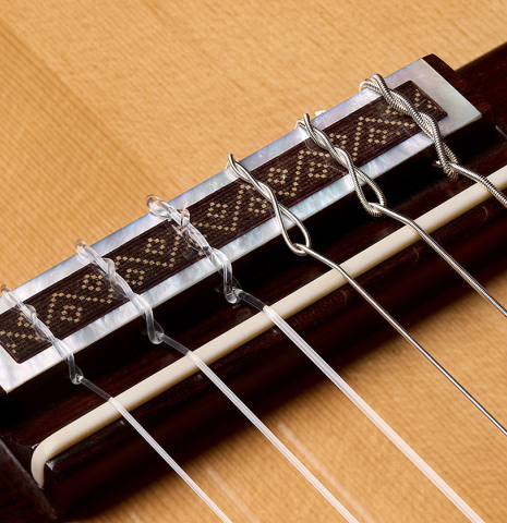 The bridge, tie-block and saddle of a 2005 Jose Marin Plazuelo "Bouchet" classical guitar made of spruce and CSA rosewood
