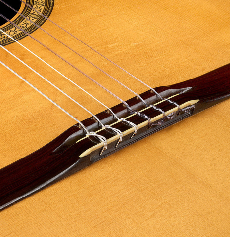 The pin bridge and tie-block of a 1987 Richard Prenkert classical guitar made of spruce and CSA rosewood