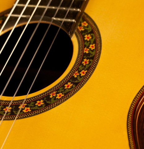This is the a close-up of the front and rosette of a Jose Ramirez "130 Anos" classical guitar built in 2014. It has a spruce soundboard and Indian rosewood back and sides.