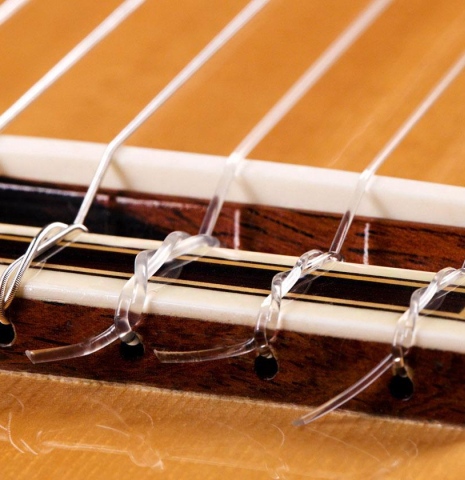 The bridge, tie-block and saddle of a 2004 Jose Ramirez "1a" classical guitar made of spruce and CSA rosewood