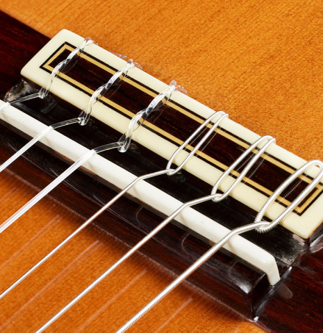 The bridge, tie-block and saddle of a 2001 Jose Ramirez "1a Tradicional" classical guitar made of cedar and Indian rosewood