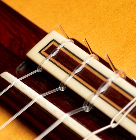 The tie block and bridge of a 2007 Jose Ramirez "1a C650-AP" classical guitar made of spruce and CSA rosewood.