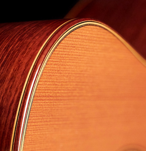 The side and binding of a 1998 Jose Ramirez "1a Tradicional - Lefty" classical guitar made with cedar and Indian rosewood.
