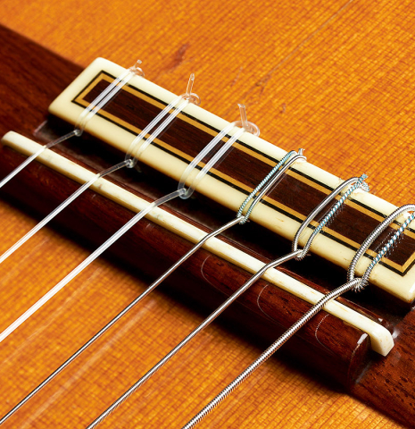 The bridge, tie-block and saddle of a 1989 Jose Ramirez "1a" (ex Gianvito Pulzone) classical guitar made of cedar and Indian rosewood