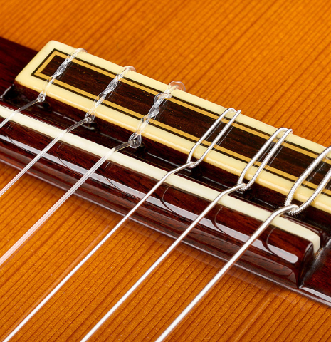 The bridge, tie-block and saddle of a 1982 Jose Ramirez "1a" classical guitar made of cedar and Indian rosewood