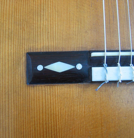 The close-up photo of the bridge of a 1892 Antonio de Torres SE 153