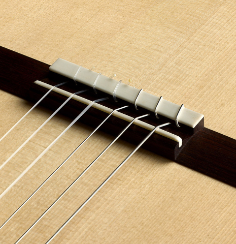 The bridge, tie-block and saddle of a 2026 Richard Reynoso classical guitar made of spruce and Indian rosewood