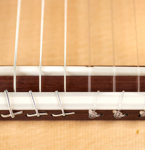 The bridge, tie-block and saddle of a 2022 Richard Reynoso classical guitar made of spruce and pau ferro