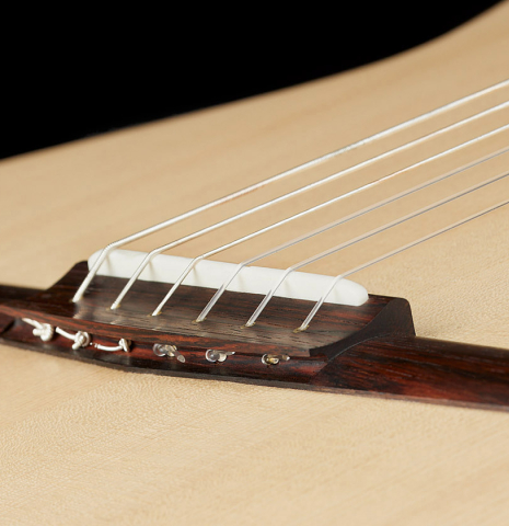 The innovative new bridge design of a 2024 Richard Reynoso w/pegs classical guitar made of spruce and Indian rosewood