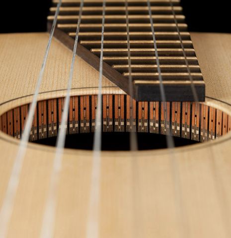 The fingerboard and soundhole of a 2024 Richard Reynoso w/pegs classical guitar made of spruce and Indian rosewood