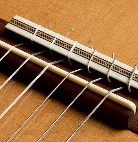 The bridge, tie-block and saddle of a 2014 Richard Reynoso classical guitar made of cedar and Indian rosewood