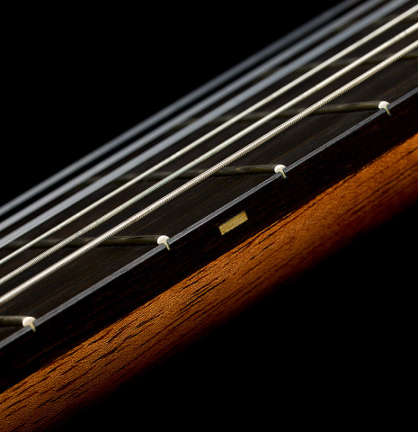 The fingerboard and fret markers of a 2014 Richard Reynoso classical guitar made of cedar and Indian rosewood