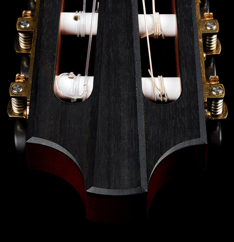 The carved headstock relief of a 2014 Richard Reynoso classical guitar made of cedar and Indian rosewood
