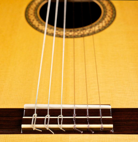 The top, bridge, tie-block and saddle of a 1996 Mikhail Robert classical guitar made of spruce and Indian rosewood