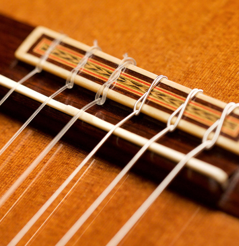 The bridge and saddle of a 1978 Miguel Rodriguez classical guitar made with redwood and Honduran rosewood