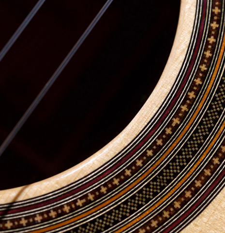 A close-up of the rosette of a 2011 Jean-Noel Rohe classical guitar made of spruce and Indian rosewood