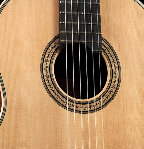 The soundboard of a 2022 Pepe Romero classical guitar made of spruce and CSA rosewood.