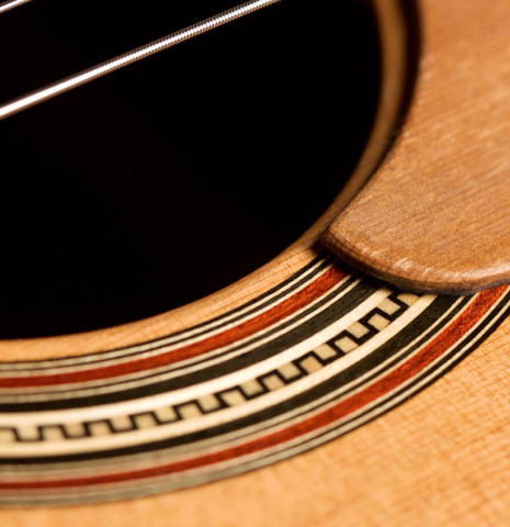 The rosette and tap plate of a 2011 Pepe Romero (ex Angel Romero) classical guitar made of cedar and African rosewood