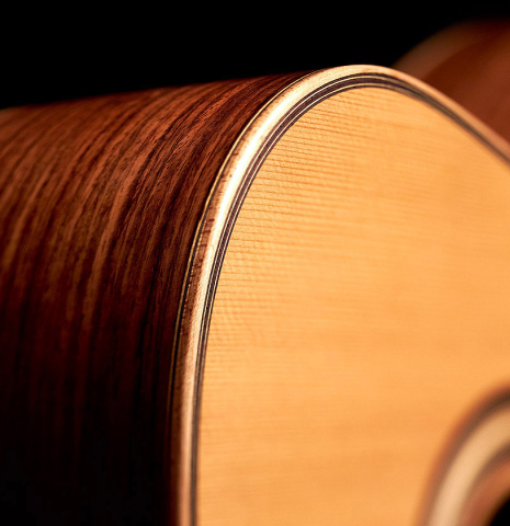 The soundboard and binding of a 2013 Bernardo Romero #1 classical guitar made of spruce and Indian rosewood