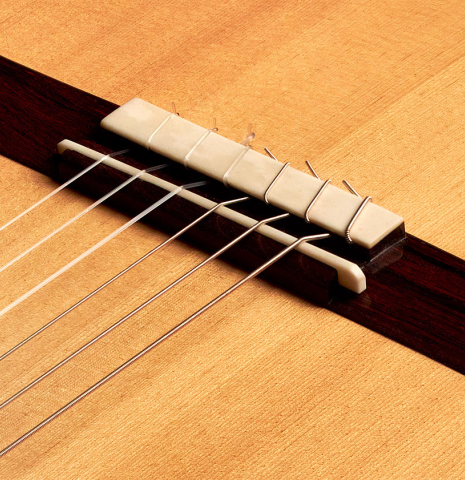 The bridge of a 2013 Bernardo Romero #1 classical guitar made of spruce and Indian rosewood