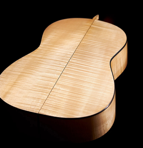 The flamed maple back and sides of a 2007 Pepe Romero classical guitar made of cedar and maple