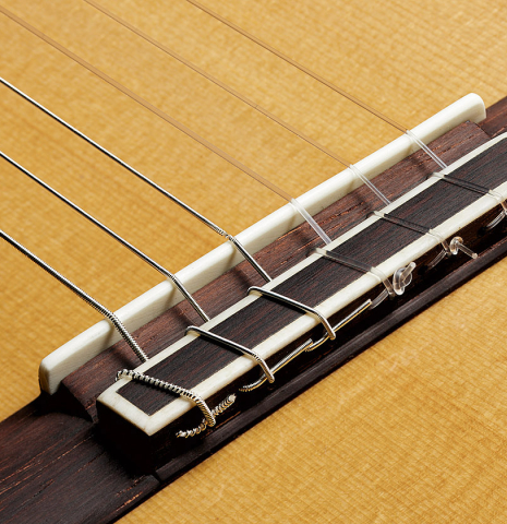 The bridge, tie-block and saddle of a 2024 Pepe Romero "cutaway" classical guitar made of spruce and CSA rosewood