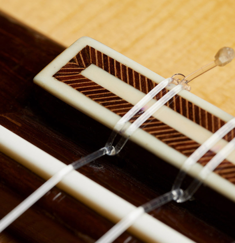 The bridge, tie-block and saddle of a 1981 Jose Romanillos "La Toronto" classical guitar made of spruce and Indian rosewood