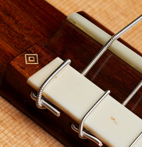The bridge, tie-block and saddle of a 2025 Jochen Rothel classical guitar made of cedar and satinwood
