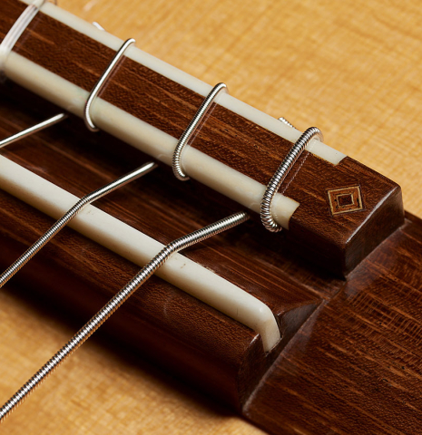 The bridge, tie-block and saddle of a 2010 Jochen Rothel classical guitar made of spruce and African rosewood