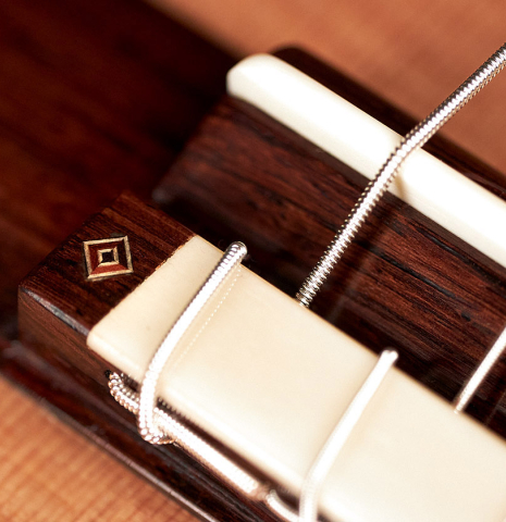 The tie-block, saddle and bridge of a 2023 Jochen Rothel classical guitar made with cedar top and African rosewood back and sides